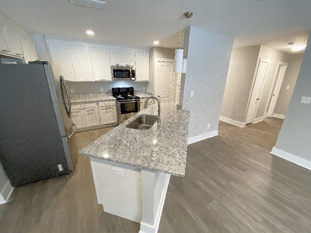 A modern kitchen with stainless-steel appliances and an open floor plan